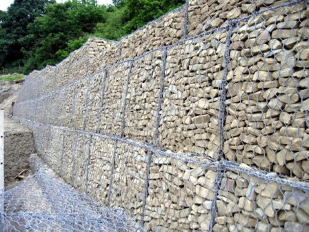 Gabions wall support of hexagonal mesh box cells filled with stones